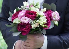 Ślubny bukiet w rękach przy fornalem - kwiaty fotografia stock Ślubny bukiet w rękach przy fornalem - kwiaty fotografia stock