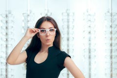 Śmieszna dziewczyna Patrzeje dla Nowych Eyeglasses w Okulistycznym sklepie obraz stock Śmieszna dziewczyna Patrzeje dla Nowych Eyeglasses w Okulistycznym sklepie obraz stock