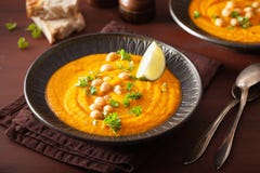 Śmietankowa marchwiana chickpea polewka na ciemnym nieociosanym tle zdjęcia stock Śmietankowa marchwiana chickpea polewka na ciemnym nieociosanym tle zdjęcia stock