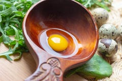 Świezi surowi przepiórek jajka w drewnianej łyżce z arugula i szpinaków sałatkowymi liśćmi obraz royalty free Świezi surowi przepiórek jajka w drewnianej łyżce z arugula i szpinaków sałatkowymi liśćmi obraz royalty free