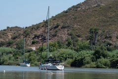 Żaglówka i motorboat cumujący na Rio Guadiana zdjęcie stock Żaglówka i motorboat cumujący na Rio Guadiana zdjęcie stock
