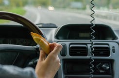 Żeńska ręka trzyma babeczkę za kołem samochód w ruchu na autostradzie zdjęcia royalty free Żeńska ręka trzyma babeczkę za kołem samochód w ruchu na autostradzie zdjęcia royalty free