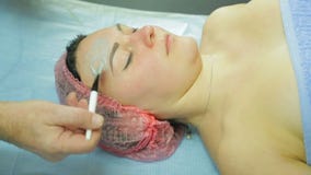 Żeński cosmetologist w rękawiczkach stosuje traktowanie maskę mężczyzny s twarz z muśnięciem Boczny widok zbiory Żeński cosmetologist w rękawiczkach stosuje traktowanie maskę mężczyzny s twarz z muśnięciem Boczny widok zbiory