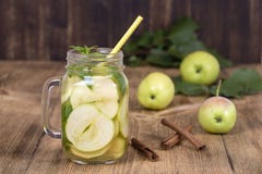Żywienioniowy detox napój z jabłko plasterkami i nowymi liśćmi w czystej wodzie i świeżym jabłku na drewnianym stole, obraz stock Żywienioniowy detox napój z jabłko plasterkami i nowymi liśćmi w czystej wodzie i świeżym jabłku na drewnianym stole, obraz stock
