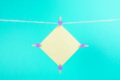 Żółty majcher na clothesline z clothespins odizolowywającymi na błękitnym tle fotografia stock Żółty majcher na clothesline z clothespins odizolowywającymi na błękitnym tle fotografia stock