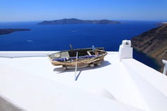 Άποψη θάλασσας και μια παλαιά βάρκα σε μια στέγη σε Santorini στοκ φωτογραφία Άποψη θάλασσας και μια παλαιά βάρκα σε μια στέγη σε Santorini στοκ φωτογραφία