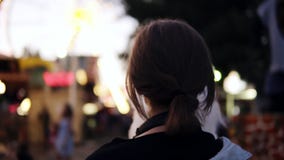 Άποψη πίσω πλευρών ενός κοριτσιού που περπατά στο λούνα παρκ, που τρώει μια καραμέλα βαμβακιού Σύντομη μαλλιαρή ξανθή φθορά γυναι απόθεμα βίντεο Άποψη πίσω πλευρών ενός κοριτσιού που περπατά στο λούνα παρκ, που τρώει μια καραμέλα βαμβακιού Σύντομη μαλλιαρή ξανθή φθορά γυναι απόθεμα βίντεο
