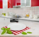 Άσπρο πιάτο στον πίνακα placemat πέρα από το σύγχρονο εσωτερικό υπόβαθρο κουζινών στοκ εικόνες με δικαίωμα ελεύθερης χρήσης Άσπρο πιάτο στον πίνακα placemat πέρα από το σύγχρονο εσωτερικό υπόβαθρο κουζινών στοκ εικόνες με δικαίωμα ελεύθερης χρήσης
