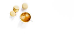 Άσπρο φλιτζάνι του καφέ με τα κίτρινα macarons στοκ εικόνα Άσπρο φλιτζάνι του καφέ με τα κίτρινα macarons στοκ εικόνα