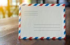 Άσπρος αναδρομικός φάκελος επιστολών ύφους κινηματογραφήσεων σε πρώτο πλάνο με το πορτοκαλί φως στοκ φωτογραφία Άσπρος αναδρομικός φάκελος επιστολών ύφους κινηματογραφήσεων σε πρώτο πλάνο με το πορτοκαλί φως στοκ φωτογραφία