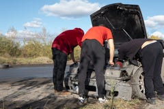 3 άτομα επισκευάζουν το χαλασμένο αυτοκίνητο κατά τη διάρκεια του ερασιτεχνικού γεγονότος μετατόπισης στοκ εικόνες 3 άτομα επισκευάζουν το χαλασμένο αυτοκίνητο κατά τη διάρκεια του ερασιτεχνικού γεγονότος μετατόπισης στοκ εικόνες