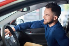 Άτομο Brunette με τη γενειάδα στην μπλε συνεδρίαση πουλόβερ στο νέο αυτοκίνητο στοκ φωτογραφία με δικαίωμα ελεύθερης χρήσης Άτομο Brunette με τη γενειάδα στην μπλε συνεδρίαση πουλόβερ στο νέο αυτοκίνητο στοκ φωτογραφία με δικαίωμα ελεύθερης χρήσης