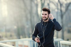 Άτομο Jogger με τα ακουστικά που χρησιμοποιούν τη μουσική Smartphone και ακούσματος Στοκ Φωτογραφία Άτομο Jogger με τα ακουστικά που χρησιμοποιούν τη μουσική Smartphone και ακούσματος Στοκ Φωτογραφία