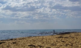 Άτομο που αλιεύει στο μπλε νερό τη νεφελώδη ημέρα στοκ φωτογραφία με δικαίωμα ελεύθερης χρήσης Άτομο που αλιεύει στο μπλε νερό τη νεφελώδη ημέρα στοκ φωτογραφία με δικαίωμα ελεύθερης χρήσης