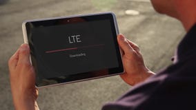 Άτομο που μεταφορτώνει το βίντεο άνω των LTE σε ένα PC ταμπλετών Άτομο που μεταφορτώνει το βίντεο άνω των LTE σε ένα PC ταμπλετών