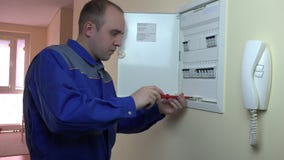 Άτομο στην μπλε ομοιόμορφη εργασία σε έναν διακόπτη στο επίπεδο σπίτι φιλμ μικρού μήκους Άτομο στην μπλε ομοιόμορφη εργασία σε έναν διακόπτη στο επίπεδο σπίτι φιλμ μικρού μήκους
