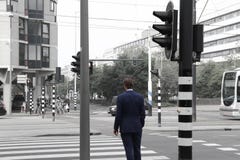 Άτομο στο κοστούμι που διασχίζει το δρόμο στοκ εικόνα Άτομο στο κοστούμι που διασχίζει το δρόμο στοκ εικόνα