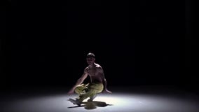 Άτομο χορευτών Breakdance στο κίτρινο παντελόνι με το γυμνό χορό κορμών στο Μαύρο, σκιά, σε αργή κίνηση φιλμ μικρού μήκους Άτομο χορευτών Breakdance στο κίτρινο παντελόνι με το γυμνό χορό κορμών στο Μαύρο, σκιά, σε αργή κίνηση φιλμ μικρού μήκους