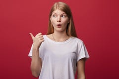 Έκπληκτα σημεία γυναικών με τον αντίχειρα κατά μέρος στοκ εικόνες Έκπληκτα σημεία γυναικών με τον αντίχειρα κατά μέρος στοκ εικόνες