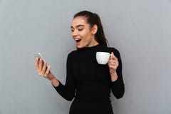 Έκπληκτη ευτυχής γυναίκα brunette στα μαύρα ενδύματα που εξετάζει έξυπνο στοκ εικόνα Έκπληκτη ευτυχής γυναίκα brunette στα μαύρα ενδύματα που εξετάζει έξυπνο στοκ εικόνα