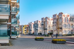 Ένα streetview με τα σύγχρονα διαμερίσματα στα αριστερά και ιστορικά σπίτια nouveau τέχνης στη δεξιά πλευρά Δύο ποδήλατα διασχίζο στοκ εικόνες Ένα streetview με τα σύγχρονα διαμερίσματα στα αριστερά και ιστορικά σπίτια nouveau τέχνης στη δεξιά πλευρά Δύο ποδήλατα διασχίζο στοκ εικόνες
