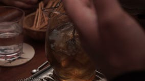 Ένα άτομο ανακατώνει τον πάγο σε ένα ποτό σε μια καράφα απόθεμα βίντεο Ένα άτομο ανακατώνει τον πάγο σε ένα ποτό σε μια καράφα απόθεμα βίντεο
