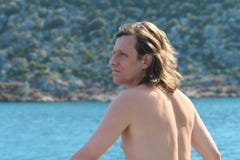 Ένα άτομο με μακρυμάλλη έχει γυρίσει την πλάτη του στη θάλασσα στοκ εικόνες Ένα άτομο με μακρυμάλλη έχει γυρίσει την πλάτη του στη θάλασσα στοκ εικόνες