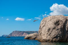 Ένα άτομο πηδά στη θάλασσα από έναν βράχο στοκ εικόνες με δικαίωμα ελεύθερης χρήσης Ένα άτομο πηδά στη θάλασσα από έναν βράχο στοκ εικόνες με δικαίωμα ελεύθερης χρήσης