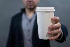 Ένα άτομο σε ένα σακάκι και ένα πουκάμισο που κρατούν ένα φλυτζάνι της Λευκής Βίβλου κενό λευκό για το κείμενό σας στοκ φωτογραφίες Ένα άτομο σε ένα σακάκι και ένα πουκάμισο που κρατούν ένα φλυτζάνι της Λευκής Βίβλου κενό λευκό για το κείμενό σας στοκ φωτογραφίες