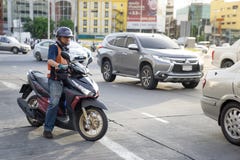 Ένα άτομο ταξί μοτοσικλετών παράδοσης απελευθερώνει έναν κύκλο μηχανών στο πολυάσχολο s στοκ εικόνες με δικαίωμα ελεύθερης χρήσης Ένα άτομο ταξί μοτοσικλετών παράδοσης απελευθερώνει έναν κύκλο μηχανών στο πολυάσχολο s στοκ εικόνες με δικαίωμα ελεύθερης χρήσης