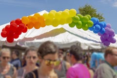 Ένα έμβλημα μπαλονιών ουράνιων τόξων πάνω από μια σκηνή στο φεστιβάλ υ στοκ εικόνες Ένα έμβλημα μπαλονιών ουράνιων τόξων πάνω από μια σκηνή στο φεστιβάλ υ στοκ εικόνες