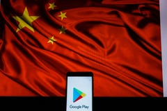 Ένα αρρενωπός-smartphone που παρουσιάζει λογότυπο καταστημάτων παιχνιδιού Google μπροστά από τη σημαία της Κίνας στοκ φωτογραφία με δικαίωμα ελεύθερης χρήσης Ένα αρρενωπός-smartphone που παρουσιάζει λογότυπο καταστημάτων παιχνιδιού Google μπροστά από τη σημαία της Κίνας στοκ φωτογραφία με δικαίωμα ελεύθερης χρήσης
