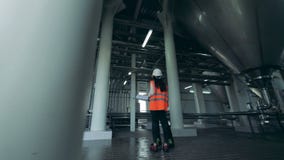 Ένα αρσενικό και θηλυκοί μηχανικοί έχει μια συνομιλία στη μονάδα ζυθοποιείων απόθεμα βίντεο Ένα αρσενικό και θηλυκοί μηχανικοί έχει μια συνομιλία στη μονάδα ζυθοποιείων απόθεμα βίντεο