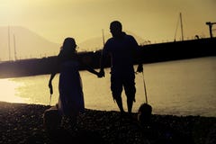 Ένα ευτυχές ζεύγος παίρνει το σκυλί τους για έναν περίπατο στην παραλία στοκ φωτογραφίες Ένα ευτυχές ζεύγος παίρνει το σκυλί τους για έναν περίπατο στην παραλία στοκ φωτογραφίες