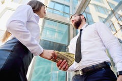 Ένα κορίτσι δίνει ένα άτομο στα χέρια των χρημάτων στο υπόβαθρο στοκ φωτογραφίες Ένα κορίτσι δίνει ένα άτομο στα χέρια των χρημάτων στο υπόβαθρο στοκ φωτογραφίες