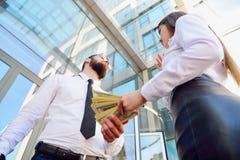 Ένα κορίτσι δίνει ένα άτομο στα χέρια των χρημάτων στο υπόβαθρο στοκ φωτογραφίες με δικαίωμα ελεύθερης χρήσης Ένα κορίτσι δίνει ένα άτομο στα χέρια των χρημάτων στο υπόβαθρο στοκ φωτογραφίες με δικαίωμα ελεύθερης χρήσης