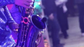 Ένα κορίτσι με ένα saxophone, μια μουσική ομάδα κοριτσιών με ένα saxophone αποδίδει στη σκηνή, ένα μπλε φόρεμα, ένα σκηνικό φως, απόθεμα βίντεο Ένα κορίτσι με ένα saxophone, μια μουσική ομάδα κοριτσιών με ένα saxophone αποδίδει στη σκηνή, ένα μπλε φόρεμα, ένα σκηνικό φως, απόθεμα βίντεο