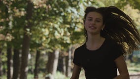 Ένα κορίτσι που τρέχει στα τρεξίματα Forest Park γύρω από μια κάμψη με τη κάμερα που ακολουθεί την από το μπροστινό 120fps απόθεμα βίντεο Ένα κορίτσι που τρέχει στα τρεξίματα Forest Park γύρω από μια κάμψη με τη κάμερα που ακολουθεί την από το μπροστινό 120fps απόθεμα βίντεο