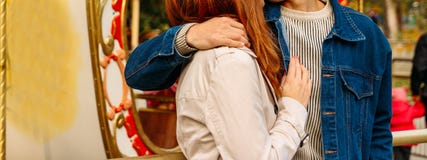 Ένα κορίτσι σε ένα μπεζ παλτό και ένας τύπος σε ένα σακάκι τζιν που αγκαλιάζει ανάμεσα σε ένα λούνα παρκ, ένας εύθυμος-πηγαίνω-κύ στοκ φωτογραφία Ένα κορίτσι σε ένα μπεζ παλτό και ένας τύπος σε ένα σακάκι τζιν που αγκαλιάζει ανάμεσα σε ένα λούνα παρκ, ένας εύθυμος-πηγαίνω-κύ στοκ φωτογραφία
