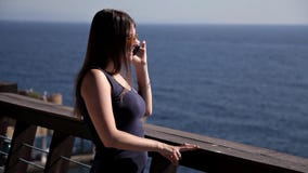 Ένα νέο κορίτσι που κοιτάζει έξω πέρα από τη θάλασσα από ένα πολυτελές πεζούλι Γυναίκα που απολαμβάνει το μπλε ουρανό που μένει σ απόθεμα βίντεο Ένα νέο κορίτσι που κοιτάζει έξω πέρα από τη θάλασσα από ένα πολυτελές πεζούλι Γυναίκα που απολαμβάνει το μπλε ουρανό που μένει σ απόθεμα βίντεο