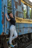 Ένα νέο όμορφο κορίτσι στέκεται στο βήμα μιας παλαιάς μεταφοράς σιδηροδρόμων, ένα τραίνο αναχώρησης Στοκ εικόνα με δικαίωμα ελεύθερης χρήσης Ένα νέο όμορφο κορίτσι στέκεται στο βήμα μιας παλαιάς μεταφοράς σιδηροδρόμων, ένα τραίνο αναχώρησης Στοκ εικόνα με δικαίωμα ελεύθερης χρήσης