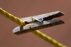 Ένα ξύλινο Clothespin που ψαλιδίζεται στη σκοινί για άπλωμα στοκ φωτογραφία Ένα ξύλινο Clothespin που ψαλιδίζεται στη σκοινί για άπλωμα στοκ φωτογραφία