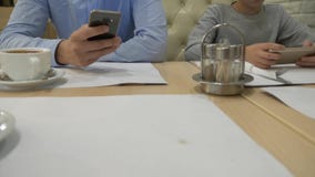 Ένα παιδί και ένα άτομο παίζουν με ένα κινητό τηλέφωνο στον πίνακα, περιμένοντας μια διαταγή σε έναν καφέ Κινηματογράφηση σε πρώτ απόθεμα βίντεο Ένα παιδί και ένα άτομο παίζουν με ένα κινητό τηλέφωνο στον πίνακα, περιμένοντας μια διαταγή σε έναν καφέ Κινηματογράφηση σε πρώτ απόθεμα βίντεο