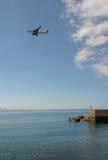 Ένα πετώντας αεροπλάνο στον ουρανό επάνω από τον ωκεανό στοκ εικόνες με δικαίωμα ελεύθερης χρήσης Ένα πετώντας αεροπλάνο στον ουρανό επάνω από τον ωκεανό στοκ εικόνες με δικαίωμα ελεύθερης χρήσης