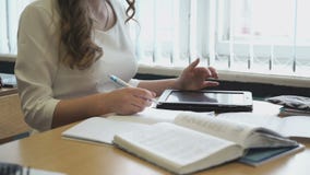 Ένα σχολικό κορίτσι γράφει σε ένα σημειωματάριο με μια μάνδρα απόθεμα βίντεο Ένα σχολικό κορίτσι γράφει σε ένα σημειωματάριο με μια μάνδρα απόθεμα βίντεο