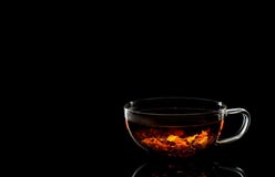 Ένα φλυτζάνι του ευώδους καυτού τσαγιού σε ένα μαύρο υπόβαθρο στοκ φωτογραφία με δικαίωμα ελεύθερης χρήσης Ένα φλυτζάνι του ευώδους καυτού τσαγιού σε ένα μαύρο υπόβαθρο στοκ φωτογραφία με δικαίωμα ελεύθερης χρήσης