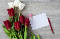 Ένα φύλλο του εγγράφου με μια κόκκινη μάνδρα και τα λουλούδια βρίσκεται σε έναν άσπρο ξύλινο πίνακα r στοκ φωτογραφία με δικαίωμα ελεύθερης χρήσης Ένα φύλλο του εγγράφου με μια κόκκινη μάνδρα και τα λουλούδια βρίσκεται σε έναν άσπρο ξύλινο πίνακα r στοκ φωτογραφία με δικαίωμα ελεύθερης χρήσης