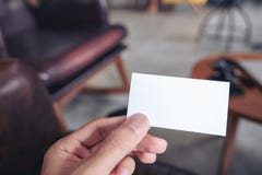 Ένα χέρι ατόμων ` s που κρατά την κενή επαγγελματική κάρτα στον καφέ στοκ εικόνες με δικαίωμα ελεύθερης χρήσης Ένα χέρι ατόμων ` s που κρατά την κενή επαγγελματική κάρτα στον καφέ στοκ εικόνες με δικαίωμα ελεύθερης χρήσης