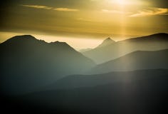 Ένα όμορφο, ζωηρόχρωμο, αφηρημένο τοπίο βουνών με μια καυτή θερινή ελαφριά ομίχλη στη θερμή πράσινη τονικότητα στοκ εικόνες Ένα όμορφο, ζωηρόχρωμο, αφηρημένο τοπίο βουνών με μια καυτή θερινή ελαφριά ομίχλη στη θερμή πράσινη τονικότητα στοκ εικόνες