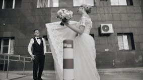Ένα όμορφο κορίτσι σε ένα άσπρο φόρεμα ταλαντεύεται παιχνιδιάρικα hem του φορέματός της μπροστά από το φίλο της Ο φίλος της εξετά φιλμ μικρού μήκους Ένα όμορφο κορίτσι σε ένα άσπρο φόρεμα ταλαντεύεται παιχνιδιάρικα hem του φορέματός της μπροστά από το φίλο της Ο φίλος της εξετά φιλμ μικρού μήκους